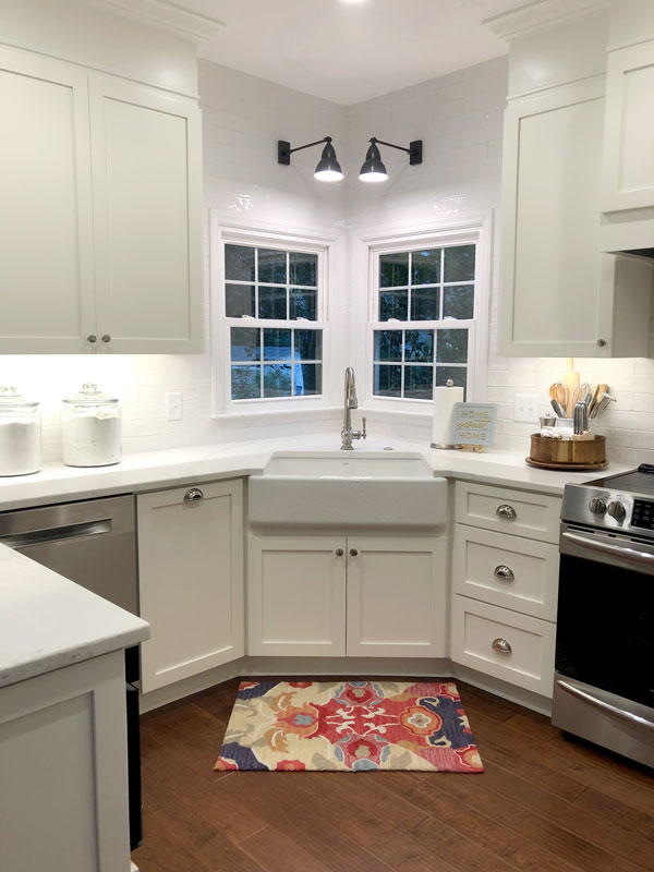 Kitchen sink with window above it, surrounded by Hartley Group Coatings white cope and stick cabinet doors and drawers with modern silver pulls.